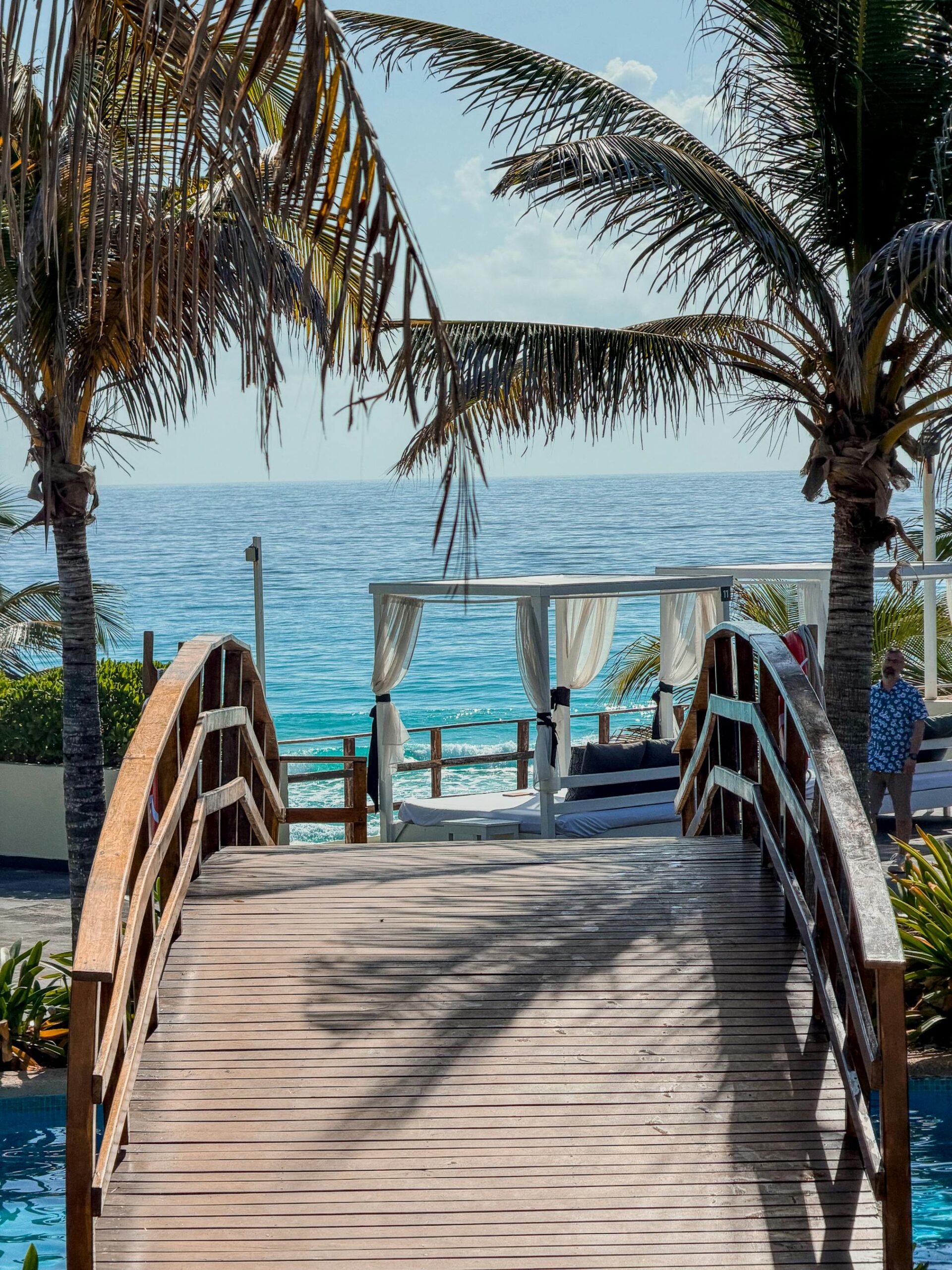 Wooden bridge offers a scenic path to the beach in Cancun, perfect for a tropical getaway.