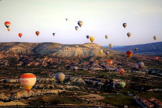 A breathtaking aerial view of vibrant hot air balloons above Cappadocia's unique landscape at sunrise.