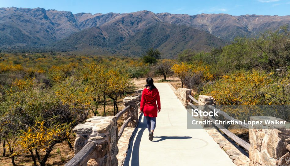 mujer en un puente de merlo san luis co montañas de fondo