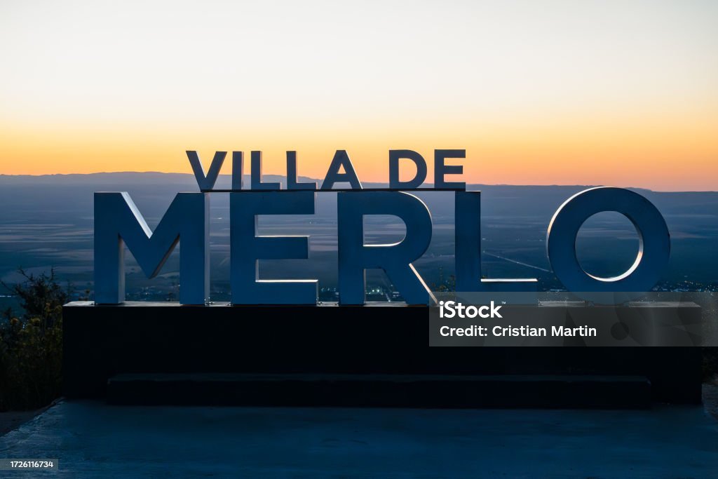 cartel de merlo san luis, en montaña al atardecer con la ciudad de fondo