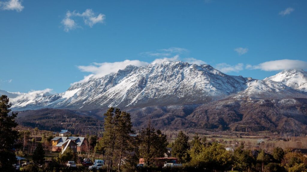 Beautiful snow-capped mountains rise above a rural village in Argentina's scenic landscape.