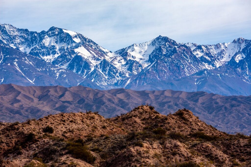 Stunning view of the Andes Mountains with snow-covered peaks and rugged terrain.