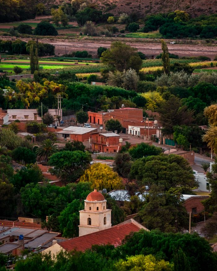 villa de merlo san luis, paquete de viaje de turismo de travelcas, pueblo rodeado de arboles con casas collor ladrillo y mucha vegetacion verde