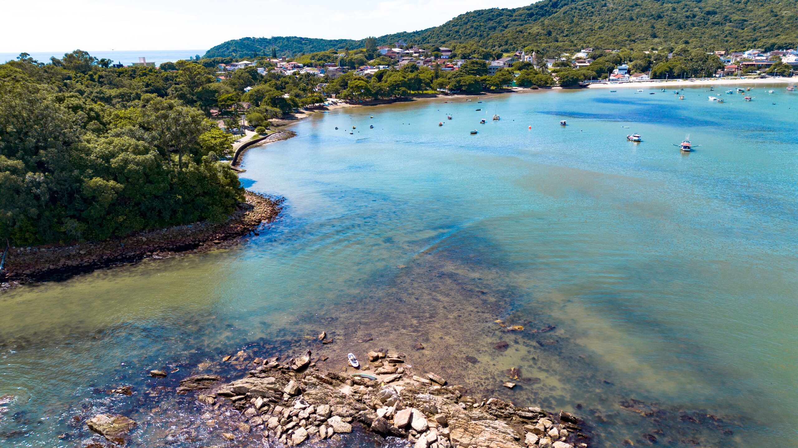 Aerial view of Bombinhas Bay in Brazil showcasing the tranquil coastline and lush greenery.