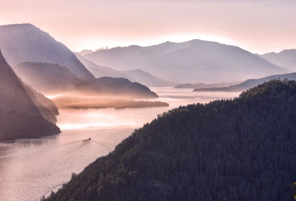 Breathtaking view of misty mountains and river in San Martín de los Andes, Argentina.